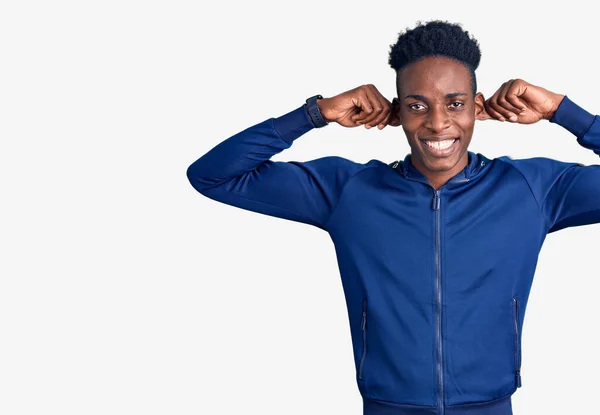 Giovane Uomo Afroamericano Che Indossa Abbigliamento Sportivo Sorridente Tirando Orecchie — Foto Stock