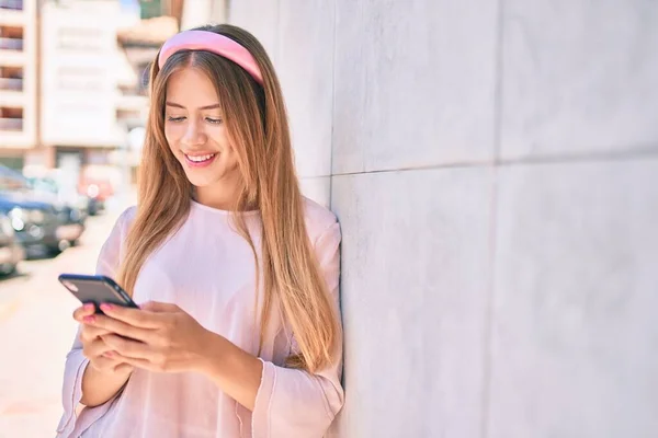 Νεαρή Καυκάσια Κοπέλα Χαμογελά Ευτυχισμένη Χρησιμοποιώντας Smartphone Ακουμπά Στον Τοίχο — Φωτογραφία Αρχείου