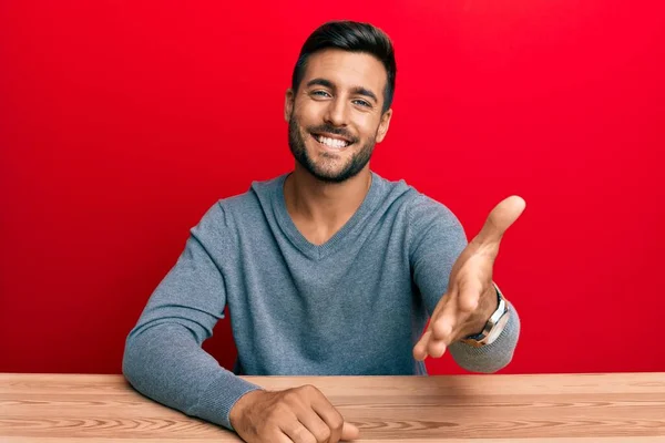 Hombre Hispano Guapo Usando Estilo Casual Sentado Mesa Sonriendo Amistoso —  Fotos de Stock