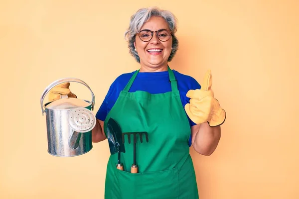 Ältere Hispanische Grauhaarige Frau Mit Gärtnerschürze Und Handschuhen Die Gießkanne — Stockfoto