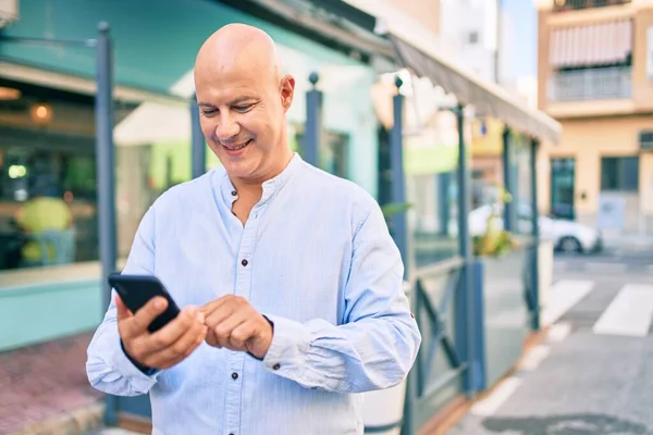 Hombre Calvo Mediana Edad Sonriendo Feliz Usando Teléfono Inteligente Ciudad —  Fotos de Stock