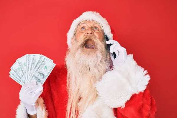 Staruszek Kostiumie Świętego Mikołaja Trzymający Dolary Smartfona Wściekły Wściekły Krzyczący — Zdjęcie stockowe