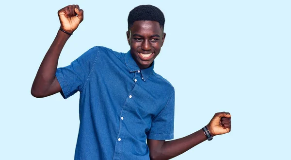 カジュアルな服を着た若いアフリカ系アメリカ人男性が幸せと陽気に踊り 笑顔でカジュアルで自信を持って音楽を聴く — ストック写真