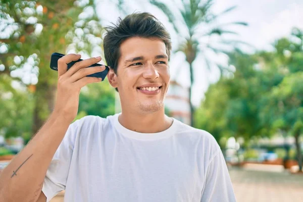 Jovem Caucasiano Sorrindo Feliz Ouvir Mensagem Áudio Usando Smartphone Cidade — Fotografia de Stock