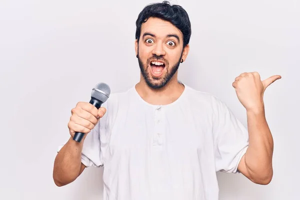 Genç Spanyol Adam Mikrofonla Şarkı Söylüyor Başparmağıyla Yan Tarafa Uzanıyor — Stok fotoğraf