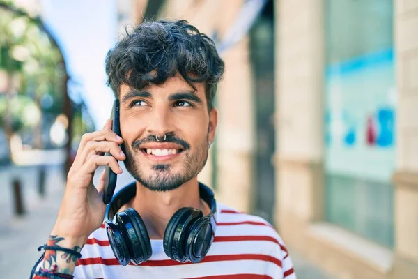 Joven Hombre Hispano Usando Auriculares Hablando Teléfono Inteligente Calle Ciudad —  Fotos de Stock