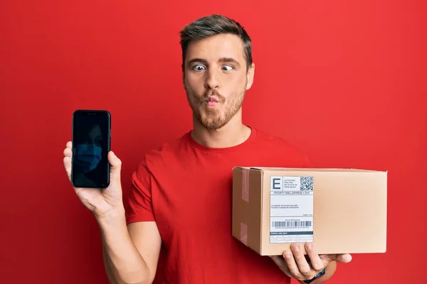 Handsome Caucasian Man Holding Delivery Package Showing Smartphone Screen Making — Stock Photo, Image