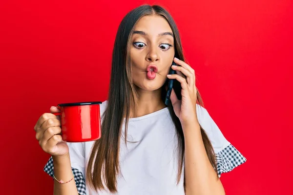 Jovem Hispânica Falando Smartphone Bebendo Uma Xícara Café Fazendo Cara — Fotografia de Stock