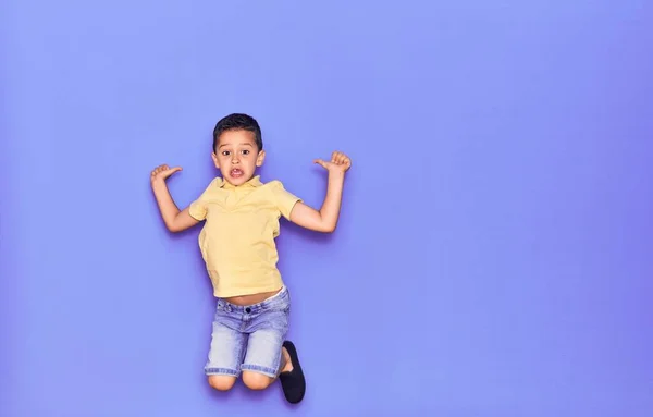 Adorable Niño Con Ropa Casual Saltando Sobre Fondo Púrpura Aislado — Foto de Stock