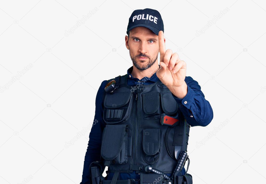 Young handsome man wearing police uniform pointing with finger up and angry expression, showing no gesture 