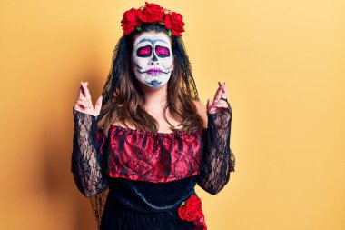 Sarı işaret parmağının üzerine ölü kostümü giymiş genç bir kadın umut ve gözlerle gülümsüyor. Şans ve batıl inançlar. 