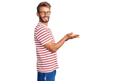 Sakallı, sıradan kıyafetler ve gözlük takan yakışıklı sarışın adam avuçlarını açıp fotokopi alanını gösteriyor. Reklam sunuyor, gülümsüyor, mutlu bir şekilde mutlu oluyor. 