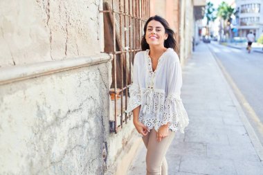 Güzel, genç bir kadın, şık kıyafetler giyip sokakta yürüyor.