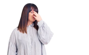 Genç ve cüsseli bir kadın sıradan kıyafetler giyiyor. Kokuşmuş ve iğrenç bir koku alıyor. Dayanılmaz bir koku. Kötü kokuyor. 