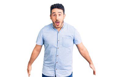 Gündelik giysiler giyen genç İspanyol adam şaşırmak için ağzı açık kalmış, korkmuş ve hayrete düşmüş, inançsız yüz. 