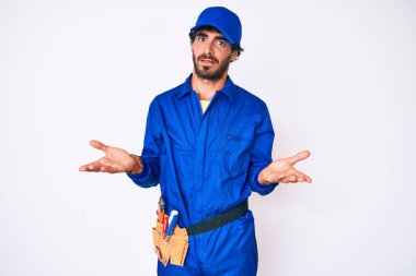 Kıvırcık saçlı ve ayı gibi giyinen yakışıklı, becerikli, kolları açık ve kafası karışık genç bir adam.. 