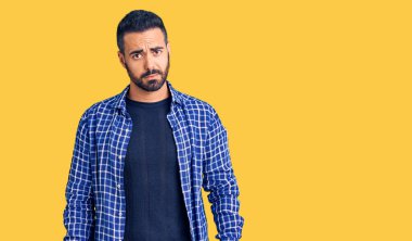 Gündelik kıyafetler giyen, kuşkucu ve gergin genç İspanyol bir adam sorun yüzünden surat asıyor. negatif kişi. 