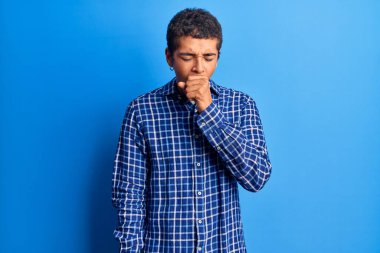 Genç Afro-Amerikalı bir adam günlük giysiler giyiyor kendini iyi hissetmiyor ve soğuk algınlığı veya bronşitin belirtisi olarak öksürüyor. sağlık hizmeti kavramı. 