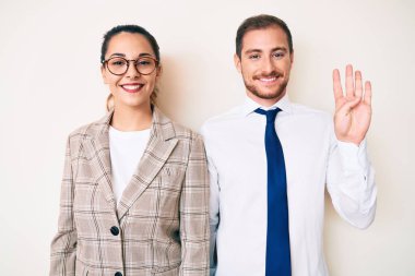 İş kıyafetleri giymiş güzel bir çift dört numarayı gösterip işaret ederken kendinden emin ve mutlu gülümsüyor.. 