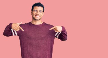 İspanyol yakışıklı, sıradan kıyafetler giyen, kendine güvenen, yüzünde gülümseme olan, kendini gururlu ve mutlu gösteren genç bir adam.. 