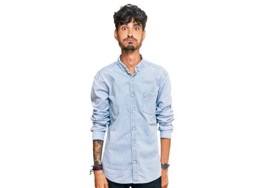 Günlük kıyafetler giyen genç İspanyol adam komik yüzlü yanakları şişiriyor. Havayla şişmiş ağız, çılgın bir ifade.. 