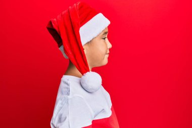 Küçük İspanyol çocuk Noel şapkası takıyor. Tarafını arıyor, rahat poz veriyor. Kendine güvenen bir gülümsemesi var.. 