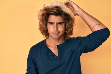 Yaz şapkası takan genç İspanyol adam soru sorup şaşırıyor. Şüpheyle kararsız, kafa kafaya düşünerek. Düşünceli kavram. 