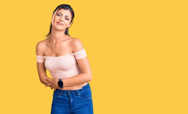 Genç ve güzel bir kadın, elleri karnında gündelik kıyafetler giyiyor çünkü hazımsızlık, acı verici bir hastalık, kendini kötü hissettiriyor. Ağrı kavramı. 