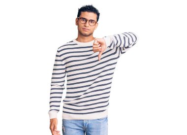 İspanyol asıllı yakışıklı genç adam, gündelik kıyafetler ve gözlük takıyor mutsuz ve kızgın görünüyor, reddediliyor ve olumsuz bir hareket yapıyor. kötü ifade. 