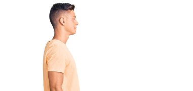 Sıradan kıyafetler giyen, rahat bir görünüm takınan, doğal yüzlü ve kendine güvenen genç yakışıklı bir adam.. 