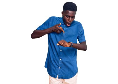 Genç Afro-Amerikan adam günlük giysiler giyiyor. Aceleyle zamanı, sabırsızlığı ve gecikmeyi gösteriyor. 