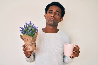 Hintli bir adam kameraya bakarak bir fincan doldurulmuş lavanta içiyor. Öpücük atıyor ve çok seksi. aşk ifadesi. 