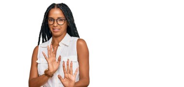 Güzel İspanyol kadın gündelik kıyafetler ve gözlük takıyor tiksindirici bir ifade takınıyor ve tiksindirici bir yüz ifadesi takınıyor. Eller havada. 