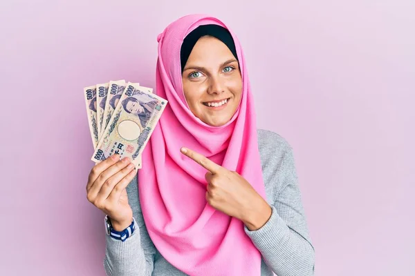 Νεαρή Λευκή Γυναίκα Που Φοράει Ισλαμική Μαντίλα Κρατώντας Ιαπωνικά Χαρτονομίσματα — Φωτογραφία Αρχείου