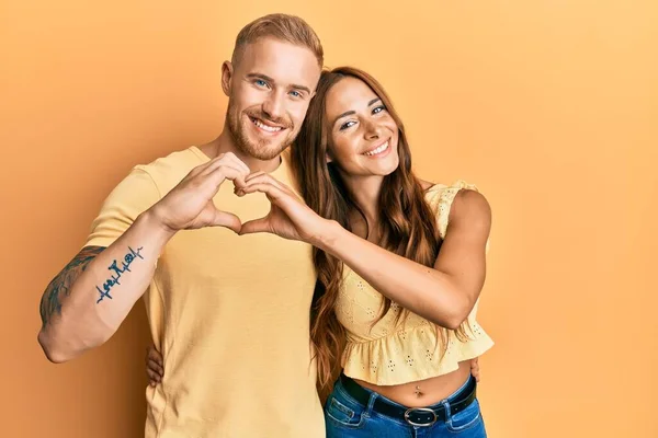 年轻夫妇的女朋友和男朋友拥抱在一起 站在一起 微笑着 用双手做着心形符号 浪漫的概念 — 图库照片