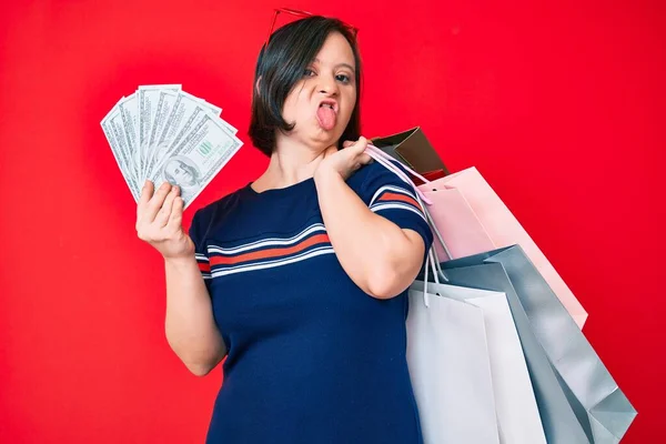 Mujer Morena Con Síndrome Sosteniendo Bolsas Compras Dólares Sacando Lengua —  Fotos de Stock