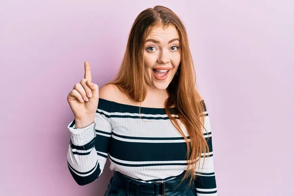 Joven Hermosa Pelirroja Vistiendo Suéter Rayas Sobre Fondo Rosa Sonriendo — Foto de Stock