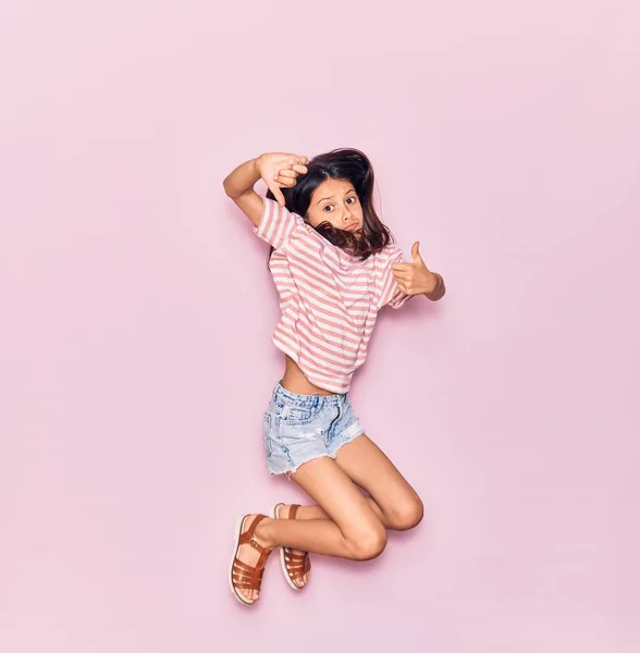 Adorable Niña Hispana Vistiendo Ropa Casual Sonriendo Feliz Saltar Con —  Fotos de Stock