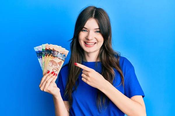 Joven Hermosa Chica Caucásica Sosteniendo Dólares Canadienses Sonriendo Feliz Señalando — Foto de Stock