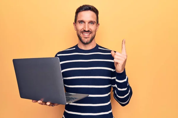 잘생긴 남자가 컴퓨터를 사용하며 위에서 손가락으로 가리키며 행복하게 있습니다 — 스톡 사진