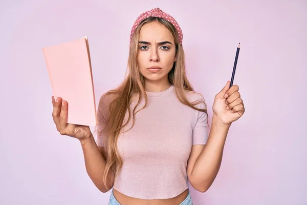 Mulher Loira Bonita Jovem Segurando Livro Lápis Cético Nervoso Franzindo — Fotografia de Stock