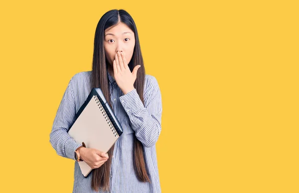 Jonge Mooie Chinese Vrouw Met Notitieboekje Mond Met Hand Geschokt — Stockfoto