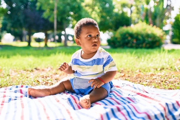 公園で草の上に座っている愛らしいアフリカ系アメリカ人の幼児 — ストック写真