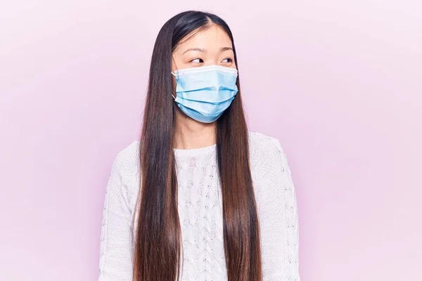 Νεαρή Όμορφη Κινέζα Γυναίκα Φορώντας Ιατρική Μάσκα Ψάχνει Για Πλευρά — Φωτογραφία Αρχείου