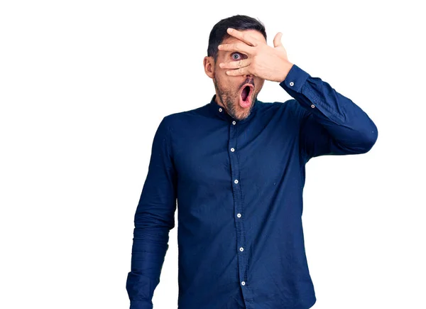 Jovem Homem Bonito Vestindo Camisa Casual Espreitando Choque Cobrindo Rosto — Fotografia de Stock