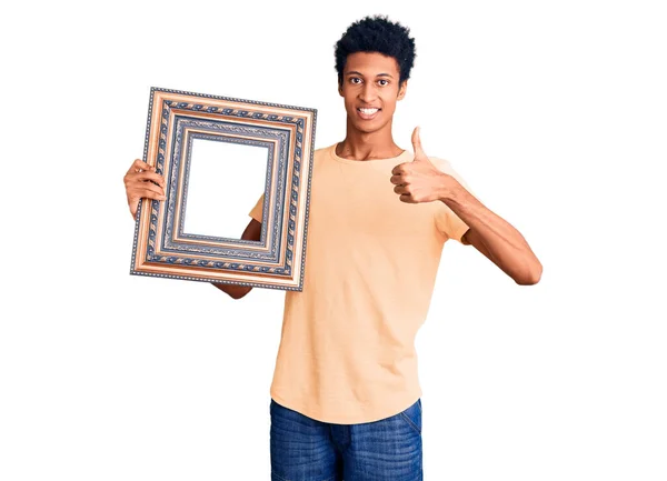 Young African American Man Holding Empty Frame Smiling Happy Positive — Stock Photo, Image