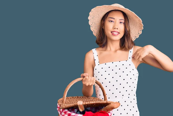 Junge Schöne Chinesische Mädchen Mit Sommermütze Hält Picknickkorb Zeigt Mit — Stockfoto