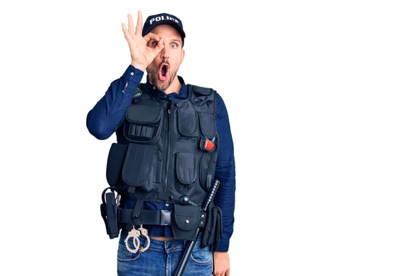 若いハンサムな男の警察の制服を着て 驚きの顔でショックを受けたOkのジェスチャーを行うと 目の指を見て 信じられない表現 — ストック写真