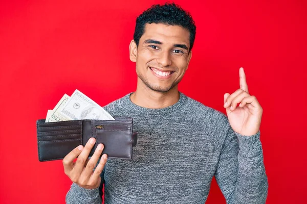 Joven Hombre Hispano Guapo Sosteniendo Billetera Con Dólares Sorprendido Con — Foto de Stock