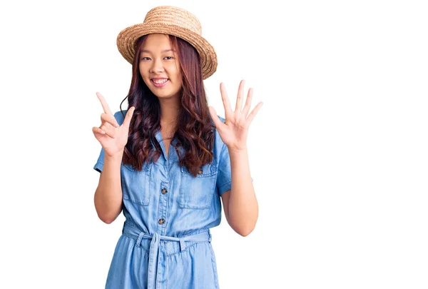 年轻美丽的中国姑娘头戴夏帽 头戴七号手指 面带微笑 自信而快乐 — 图库照片